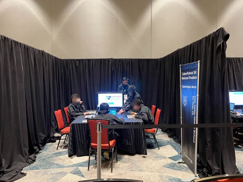 CyberAegis at the CyberPatriot National Finals booth; teammates' faces blurred
