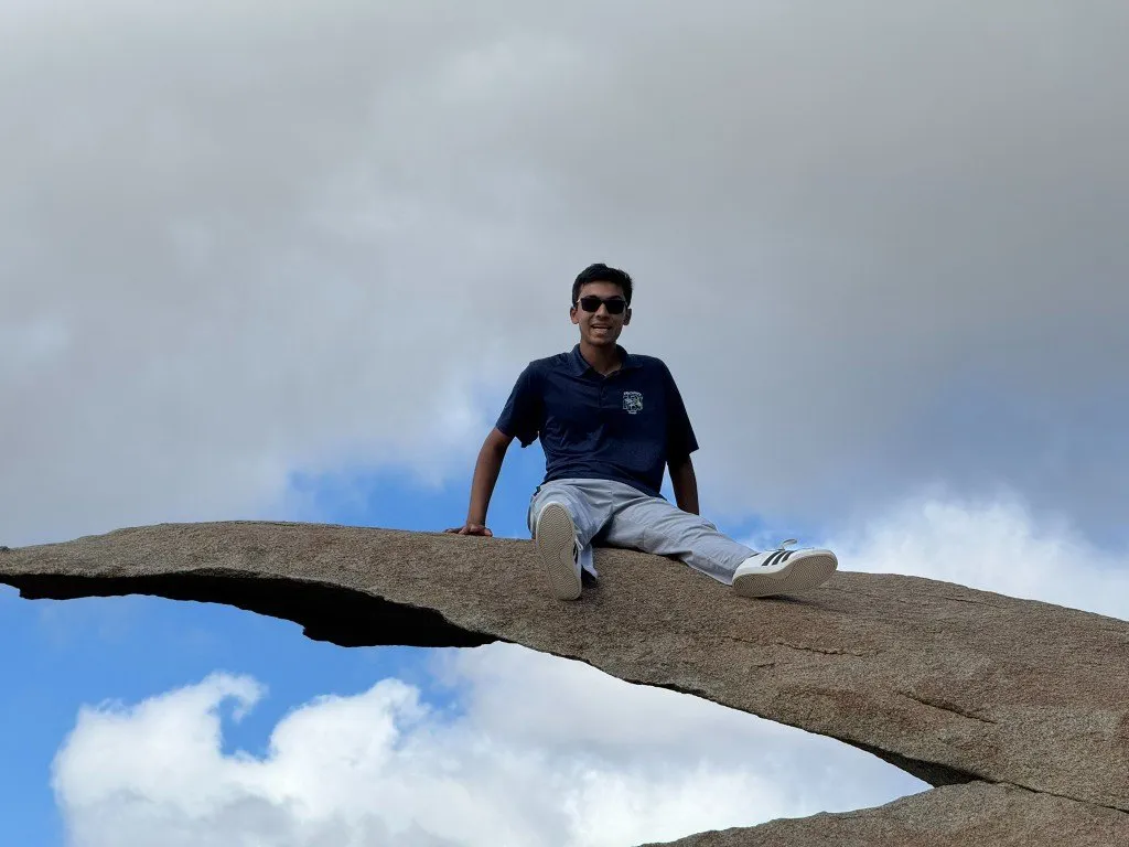 Aditya sitting on the thin edge of Potato Chip Rock